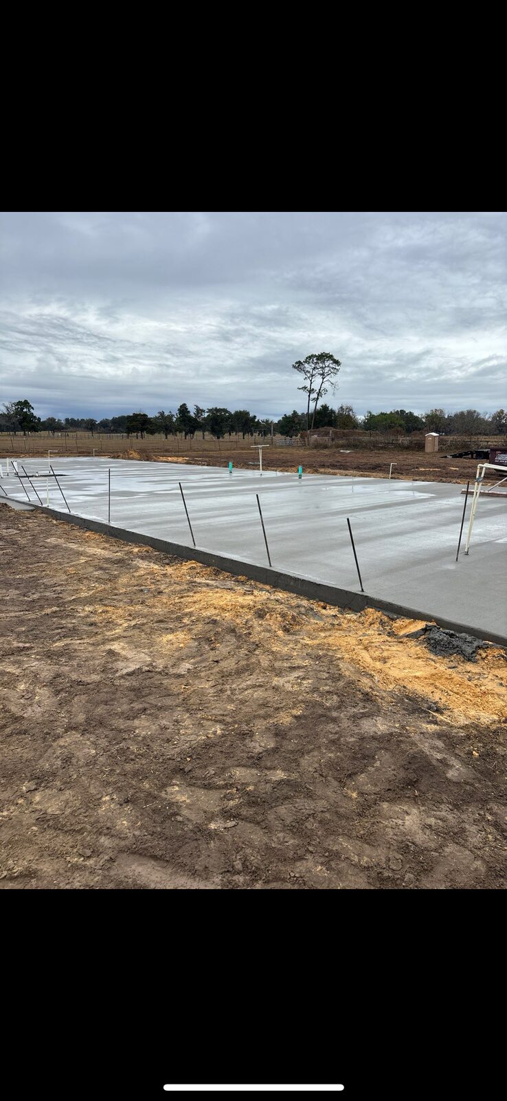 Finished concrete foundation slab with anchor bolts set